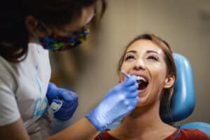 Dental hygienist examining patient's teeth during oral checkup at Prosper, TX practice.