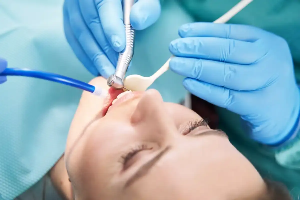 Dentist performing laser gum treatment on patient's swollen gums during dental procedure.